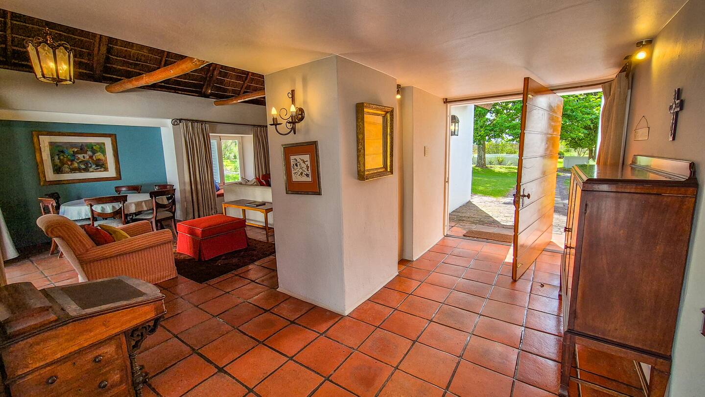 Entrance hall, terracotta floor, front door open to the lawn